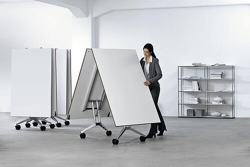 Confair folding tables in modern workspace, woman folding tabletop on mobile base