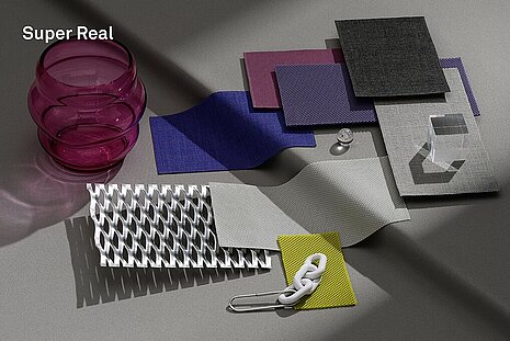 Various fabrics and objects in shades of gray, purple, and green are arranged on a light gray background. This serves as inspiration for a mood board.