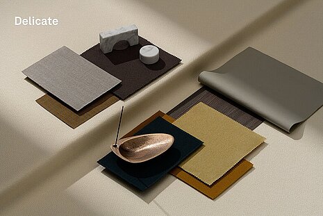 Various fabrics and objects in earth tones such as brown and beige are arranged on a light beige background. It serves as inspiration for a mood board.