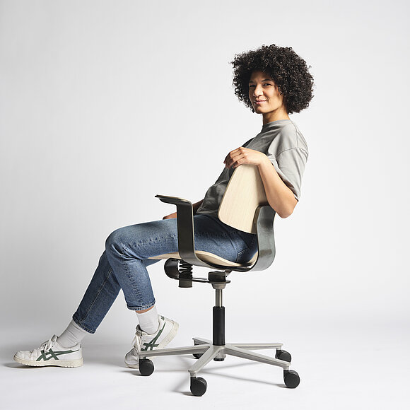 WiChair chair in studio setting, seated user demonstrating relaxed sitting posture