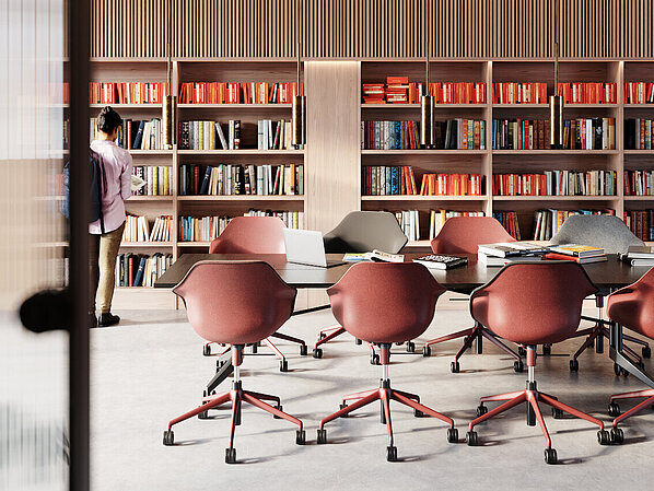 The bright library or study room is furnished with several Yonda chairs, shown here in warm shades of red and gray. The chairs blend seamlessly into the modern work environment and offer freedom of movement as well as exceptional comfort. The color-coordinated furnishings create an inspiring atmosphere for learning and working.