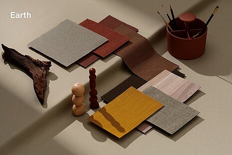 Warm earth tones and natural colors such as ochre, terracotta, sand, and brown dominate here. The selection of fabrics and materials is reminiscent of natural elements and creates a cozy, earthy, and harmonious atmosphere.