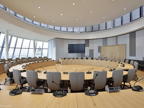 The photo shows gray Intra chairs arranged in circular rows. There is a microphone at each seat.