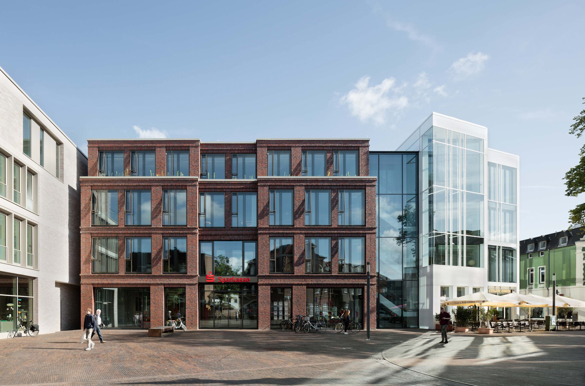 A shiny, white corner building connects the large-sized building with all its many windows and clinkered supporting structure to the new build. A distinctive, crisscrossed staircase takes center stage in the interior.