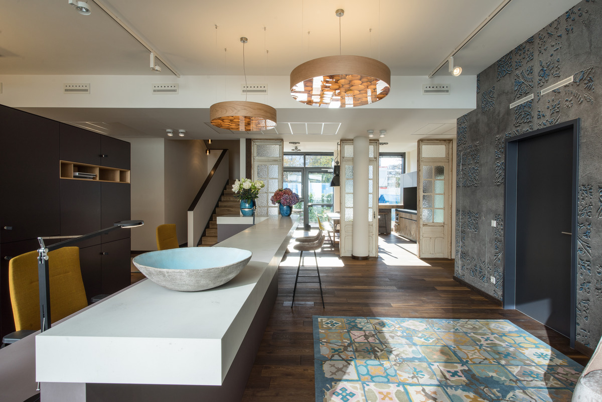 Even the reception looks more like a boutique hotel than an office. Warm, earthy colors and appealing, open-pore materials create an atmosphere that’s attractive in terms of its appearance and acoustics. Lush flower bouquets in exotic vases are a clever style contrast with the traditional office.